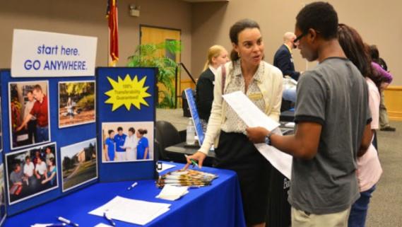 Woam n talking to young man at recruiting desk